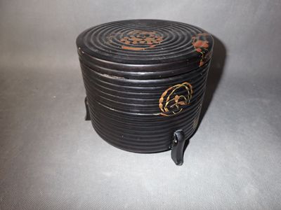 une petite boîte noire ornée d'un motif doré
