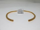 a close up of a gold bracelet with a tag on it