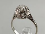 a close up of a diamond ring on a clear surface