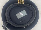 a black hat that has a gold emblem on it