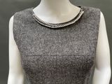 the mannequin is wearing a gray dress with pearls on the neck