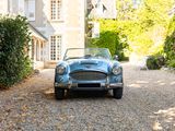 a blue car parked in the driveway of a house