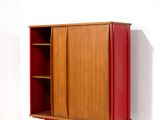 une photo d'une armoire rouge devant un mur blanc