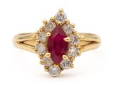 an oval ruby and diamond cluster ring in yellow gold