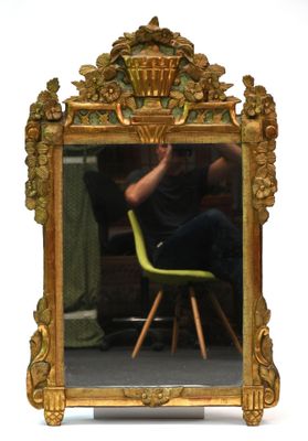 une photo d'un homme assis sur une chaise devant un miroir