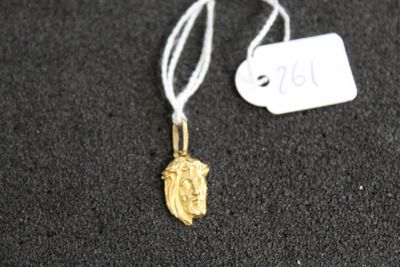 un gros plan d'un collier en or posé sur une surface noire, avec une étiquette de prix