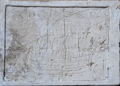 a stone plaque with a ship carved into it
