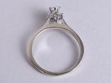 a close up of a diamond ring on a white surface
