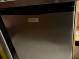 stainless steel dishwasher sitting on top of a counter in a kitchen