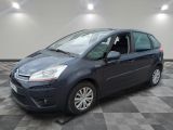 Une Citroën grise est garée sur un sol carrelé à damier.
