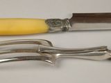 two forks and a knife on a white table