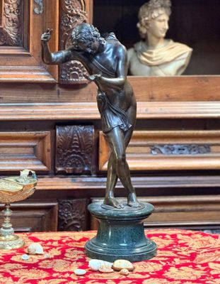 une statue représentant une femme tenant un oiseau à côté d'un vase