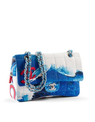 un sac à main blanc et bleu orné d'une ancre rouge