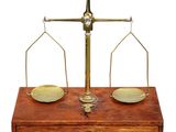 une vieille balance en laiton surmontée d'une boîte en bois