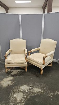 une paire de fauteuils rembourrés de couleur crème dans une pièce séparée par une cloison