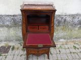 un petit bureau en bois sur lequel est posé un coussin rouge