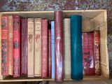 many books in a wooden box on a table