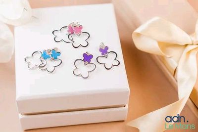 une boîte blanche sur laquelle figurent quatre papillons de couleurs différentes