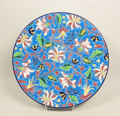 un gros plan d'une assiette bleue ornée de fleurs et de feuilles