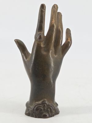 bronze statue of a hand with a ring on it ' s finger