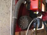 a hose attached to a wall with a red device attached to it