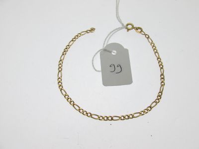 Gros plan sur un bracelet en chaîne en or portant une étiquette