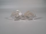two clear glass vases with flowers in them on a white surface