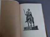 someone is holding a book with a drawing of a man on a horse