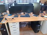 a desk with three monitors and a keyboard on it