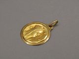 a close up of a gold medal with a virgin on it
