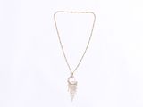 a gold necklace with a white feather charm hanging from it ' s side