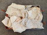 une valise remplie de lingerie posée par terre