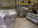 de nombreux rouleaux de papier posés sur une palette dans un entrepôt