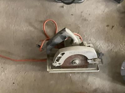 quelqu'un utilise une scie circulaire pour couper une pièce de bois