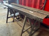 a long metal table with a red curtain in the background