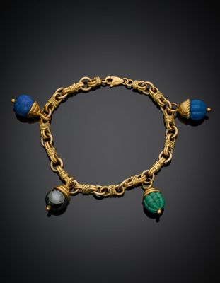 un gros plan sur un bracelet en or orné de perles bleues et vertes