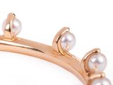 gold plated bracelet with pearls on it on a white background