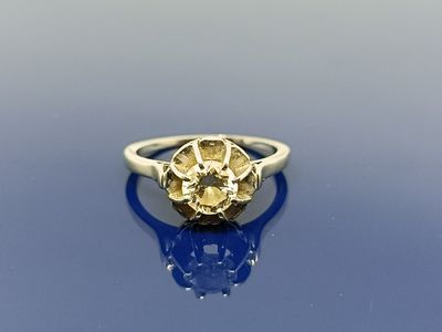 un gros plan d'une bague sertie d'un diamant jaune sur un fond bleu