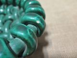 a close up of a green bracelet on a table