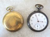 deux vieilles montres de poche posées l'une à côté de l'autre sur une table