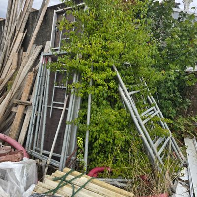 un tas de vieilleries devant un immeuble, avec une échelle