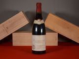 une bouteille de vin posée sur une table, à côté de deux caisses en bois