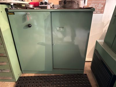 une armoire verte dans la cuisine, dont la porte est ouverte