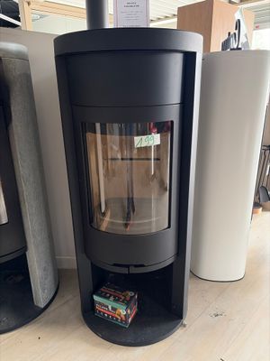 a black stove sitting on the floor next to a stack of books