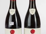 deux bouteilles de vin rouge posées l'une à côté de l'autre sur une table
