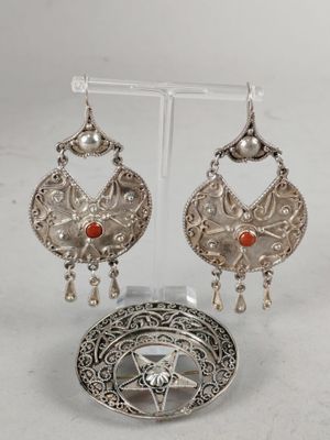 a close up of a pair of earrings on a stand
