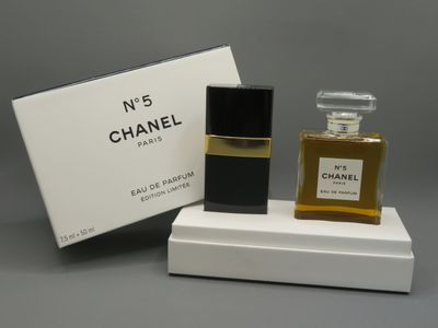 a bottle of chanel perfume sitting on top of a white box