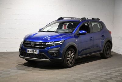 une voiture bleue est garée dans une pièce au sol à carreaux