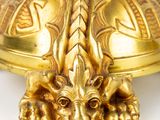 an image of a gold plate with a dragon head on it