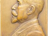 an image of a bronze plaque of a man with a beard